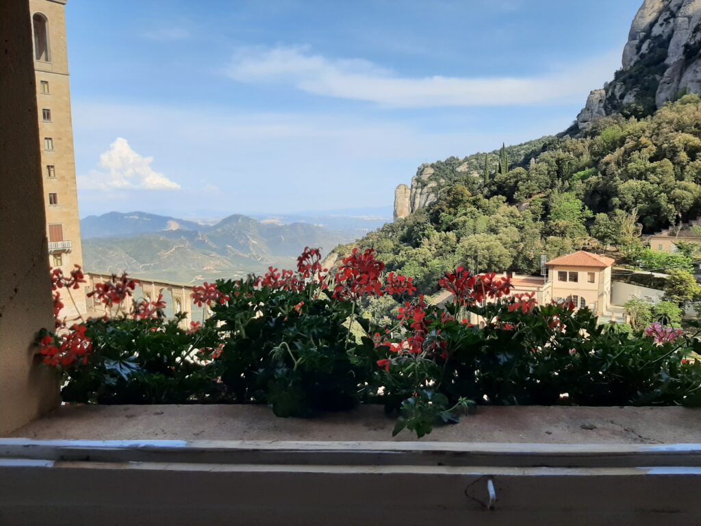 The view from the window at Montserrat, where Morrie started writing fiction again after much too long a break. The Spanish mountains are green and lush, the sky pale blue and sprinkled with a mixture of wispy clouds and distant cottony cloud-mountains.